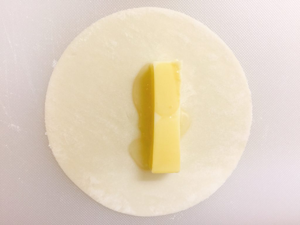 餃子の皮の上にチーズをのせはちみつをかけた画像