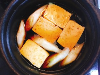 ネギと豆腐を煮汁で煮ている画像